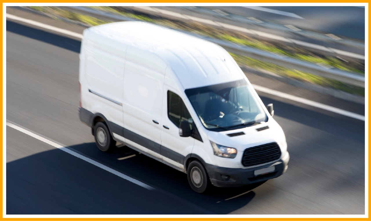 White delivery van driving on a multi-lane highway, captured from above with motion blur.