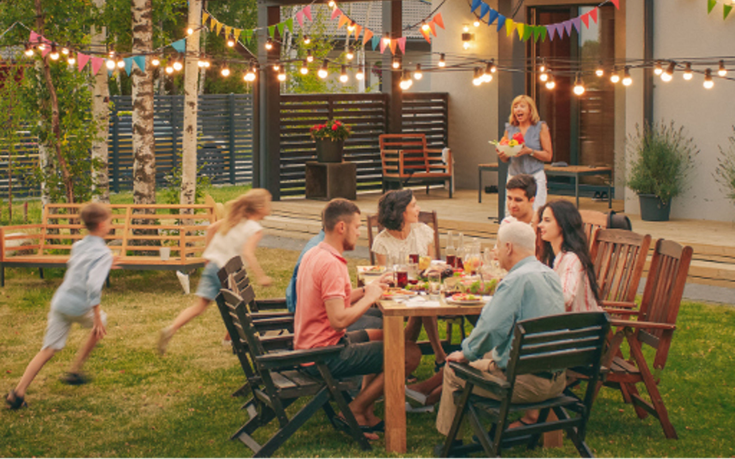 Big Family Garden Party Celebration, Gathered Together at the Table Family, Friends and Children. People are Drinking, Passing Dishes, Joking and Having Fun. Kids Run Around Table. (Big Family Garden Party Celebration, Gathered Together at the Table F