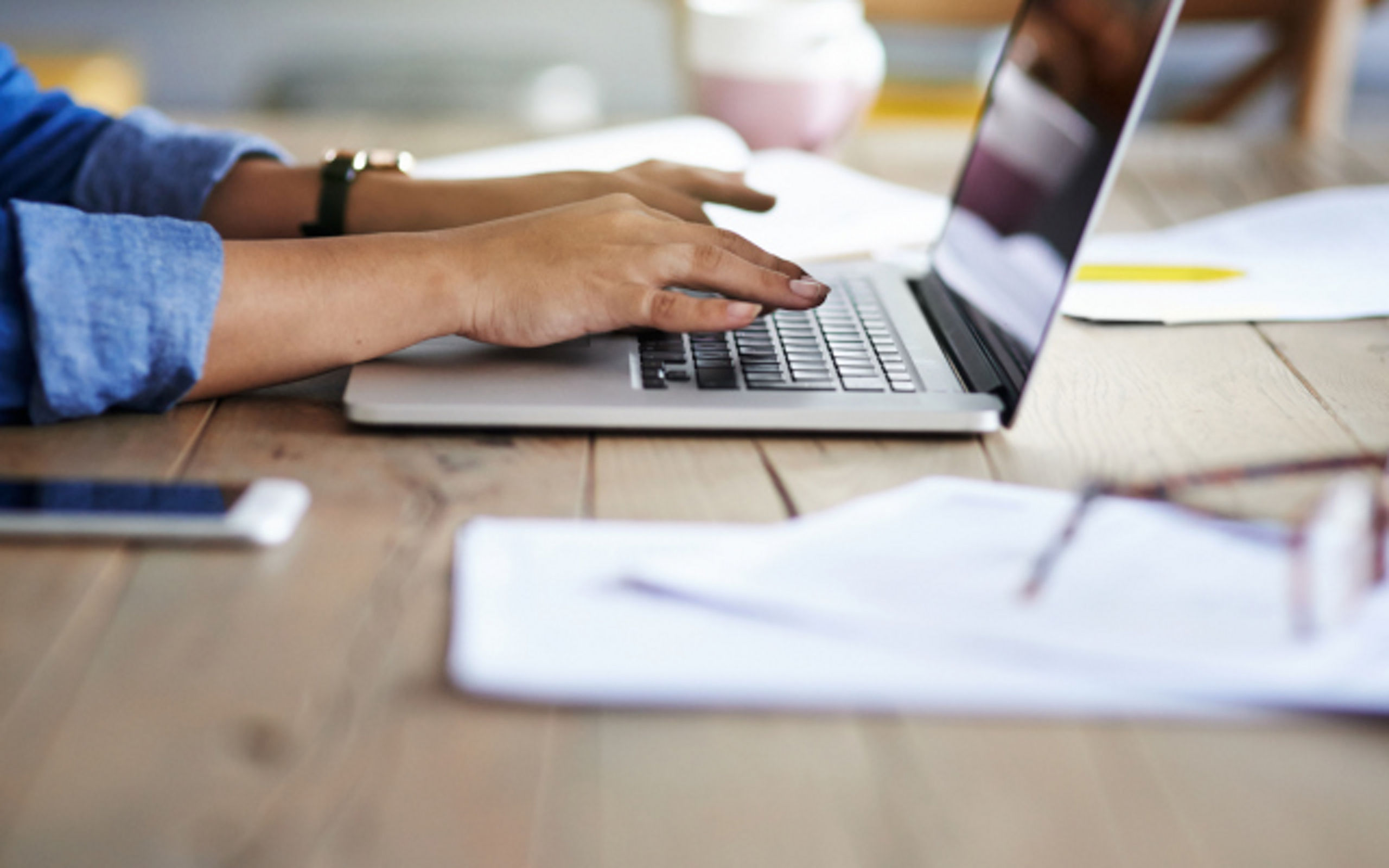 Cropped shot of a woman using a laptop while working from home