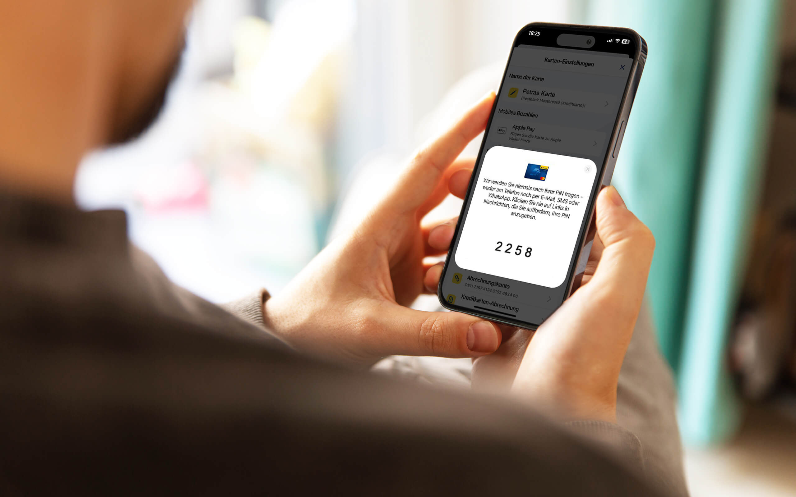 Eine sitzende Person nutzt die Funktion zum Anzeigen der PIN in der Postbank App