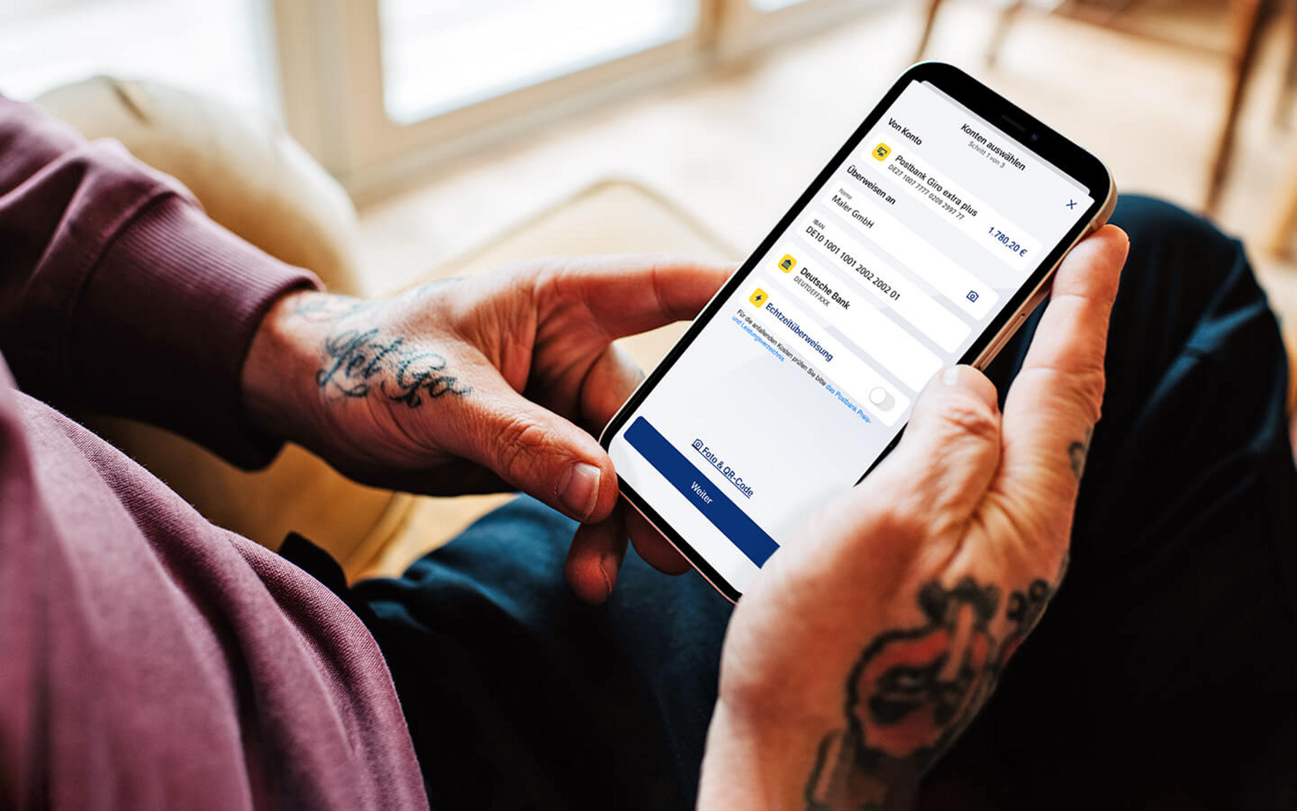 Eine Person schaut auf eine Handy mit der Postbank App