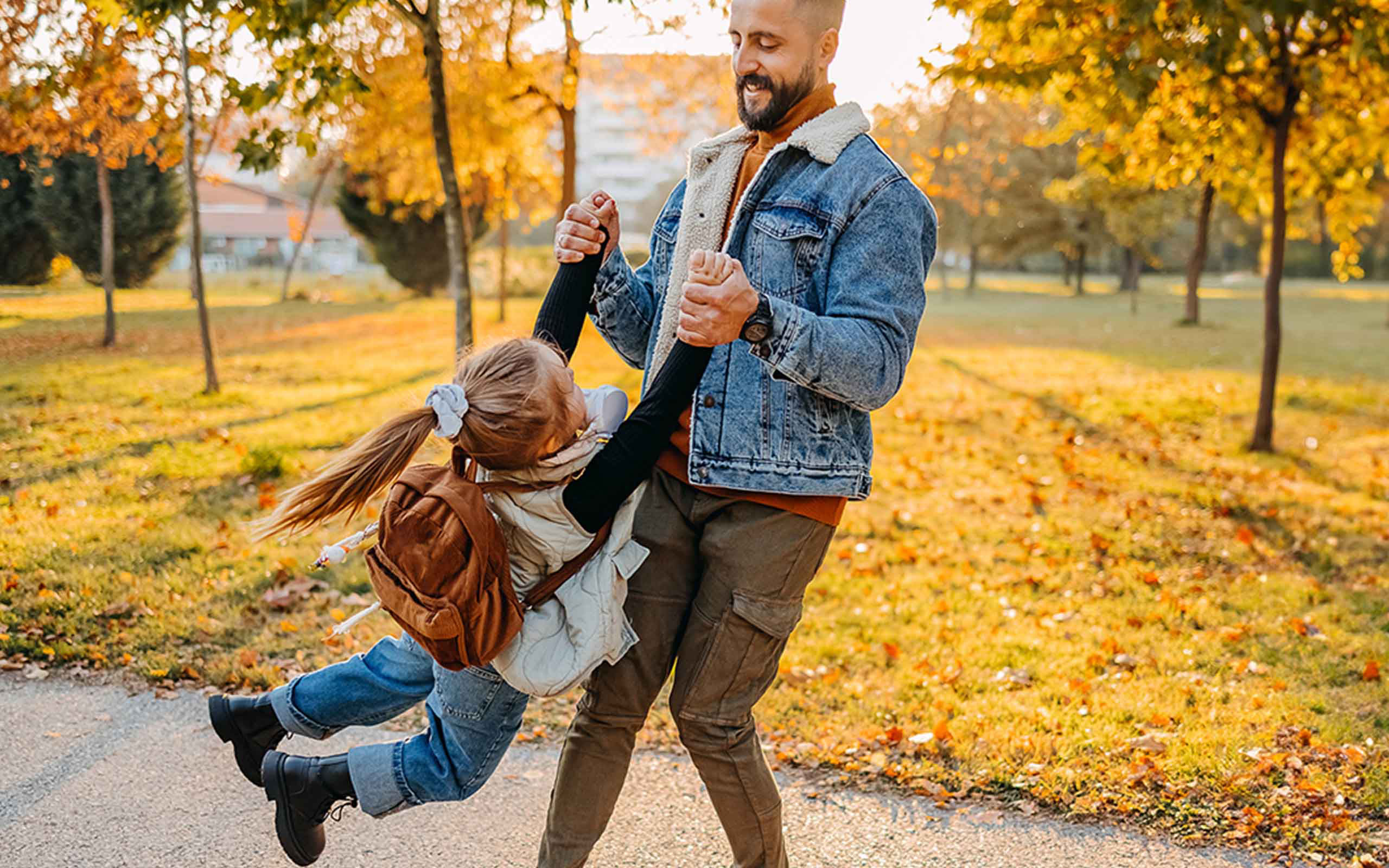 Eine Vater spielt mit seiner Tochter auf einer herbstlichen Wiese