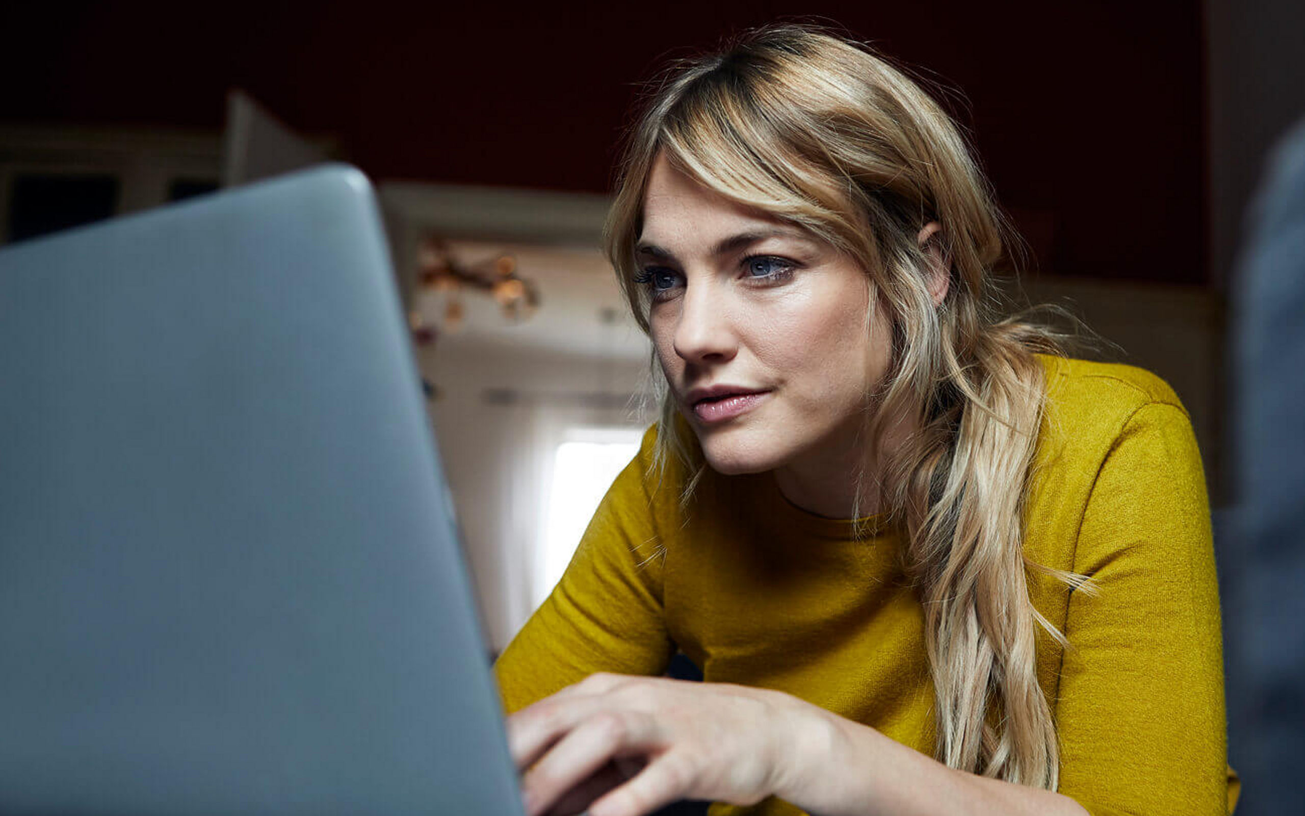 Eine junge Frau sieht konzentriert auf ihren Laptop