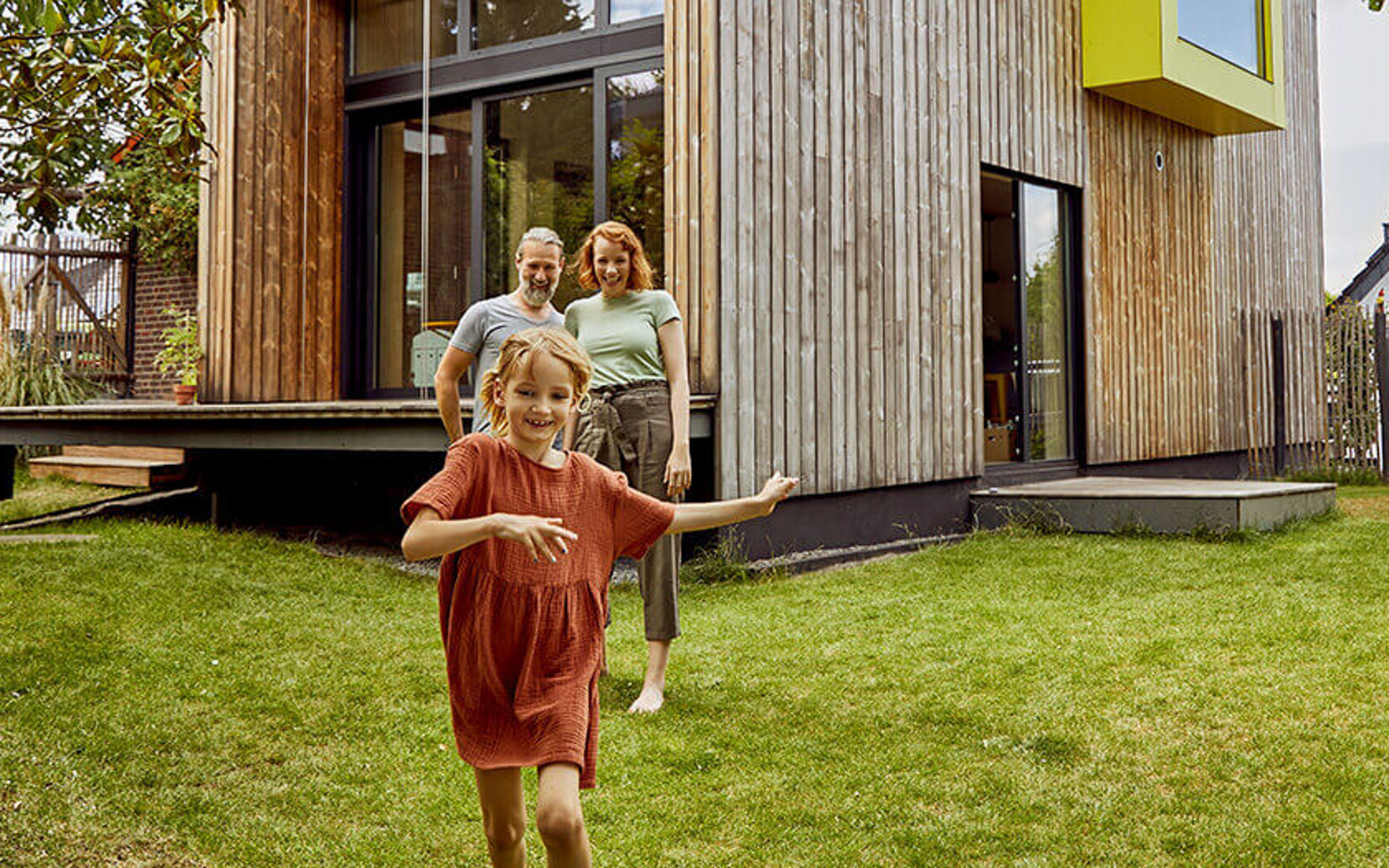 Eine junge Familie vor einem Tiny House