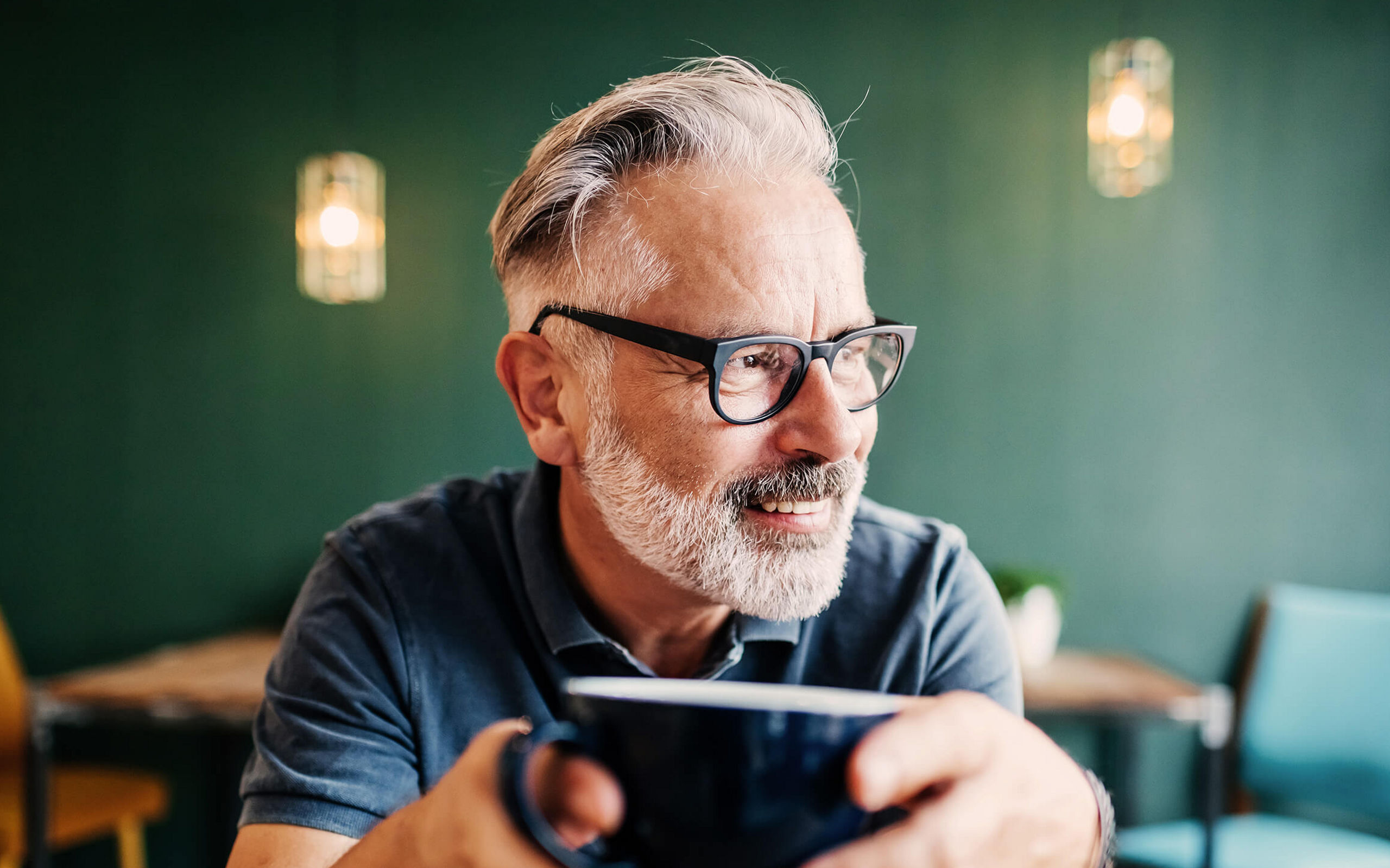 Ein Mann mittleren Alters mit einer Kaffeetasse