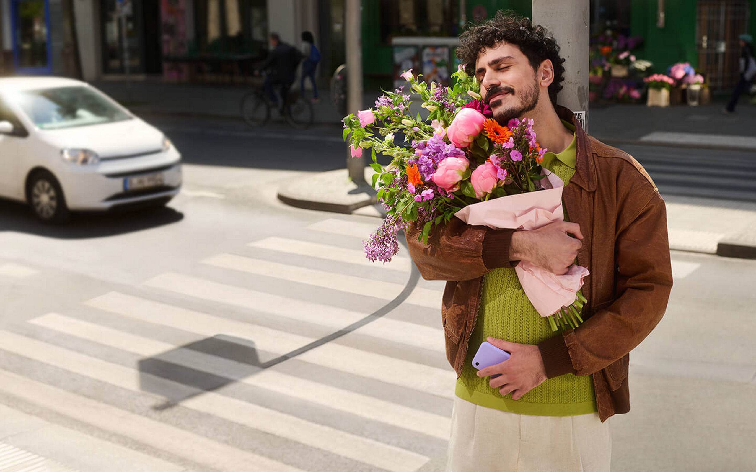 Ein Mann steht auf einer Straße mit einem bunten Blumenstrauß