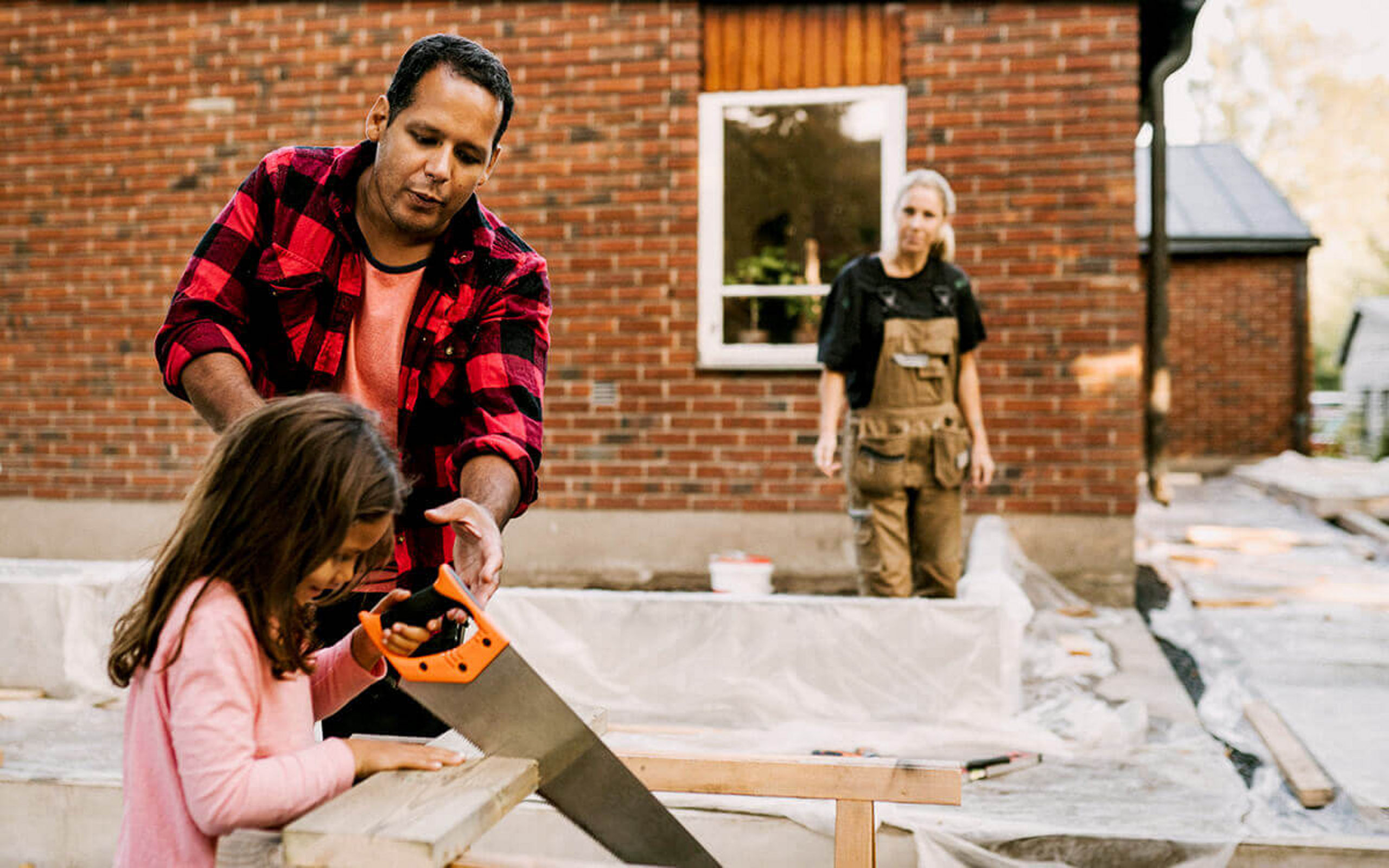 Eine Tochter hilft ihrem Vater auf der eigenen Baustelle