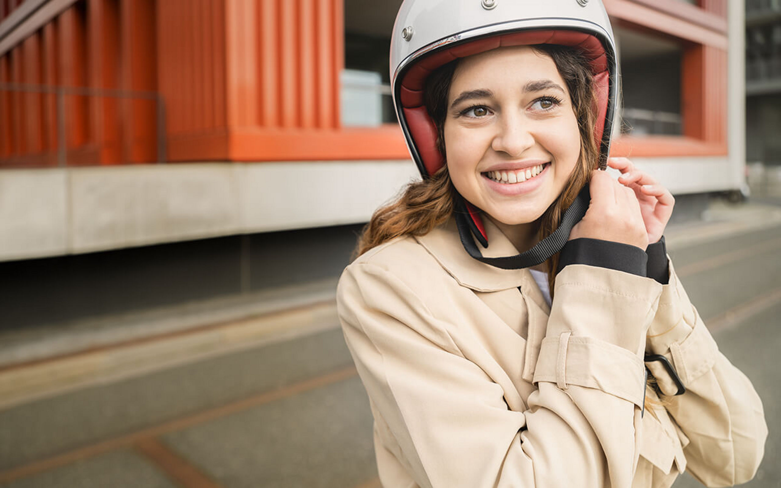 Eine junge Frau setzt sich gerade einen Helm auf
