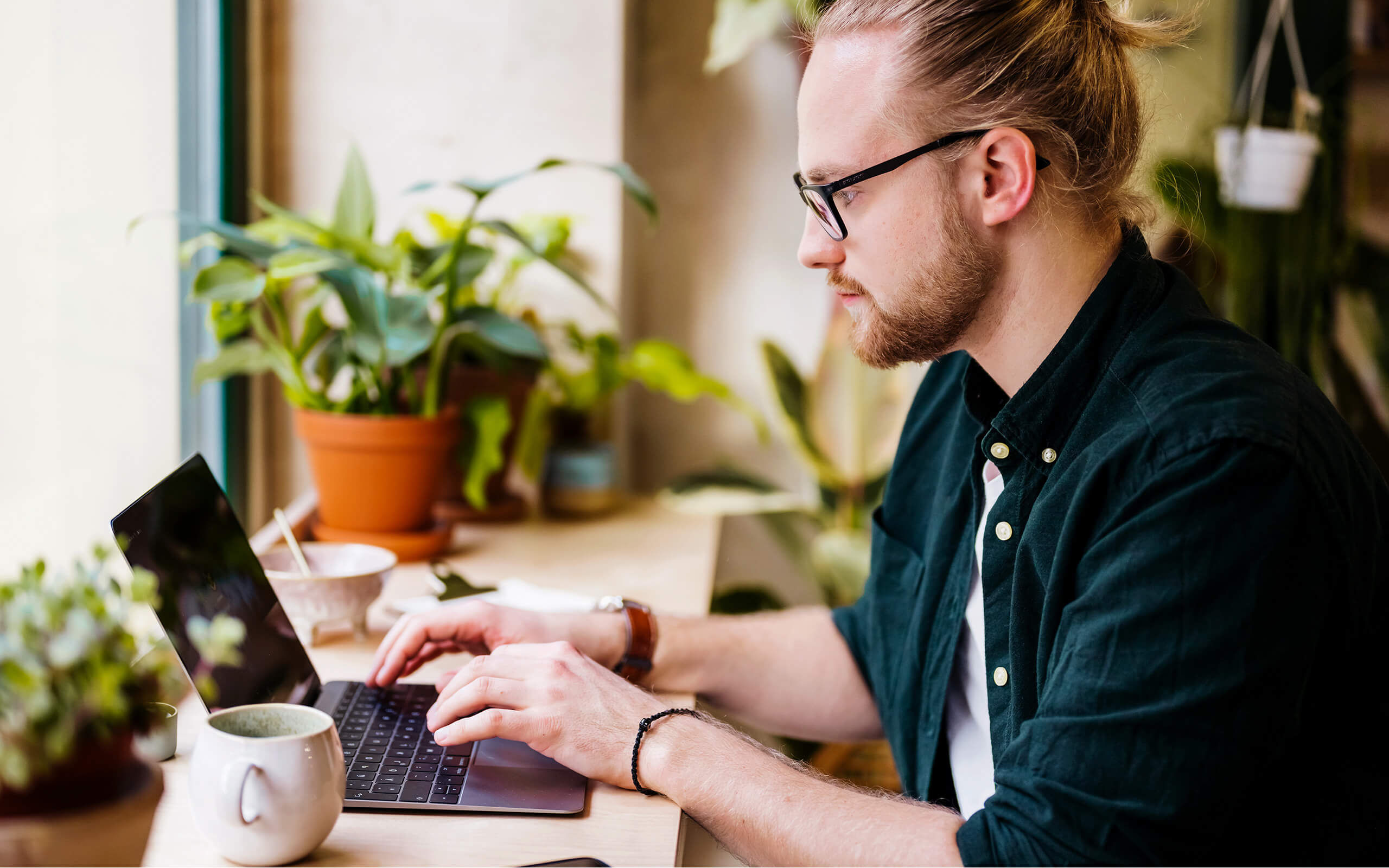 Eine junger Mann arbeitet an einem Laptop