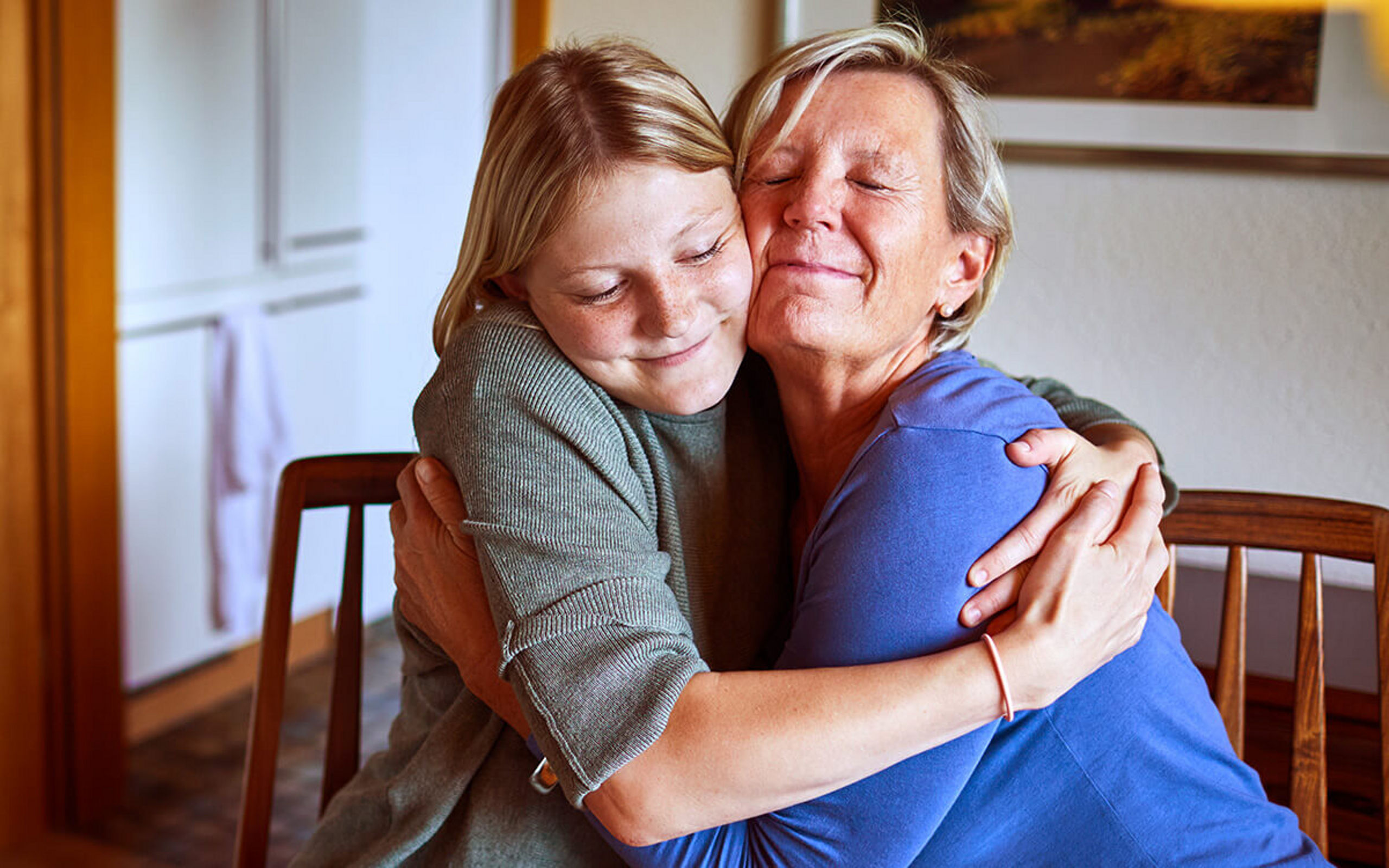 Eine ältere Dame und eine junge Frau umarmen sich