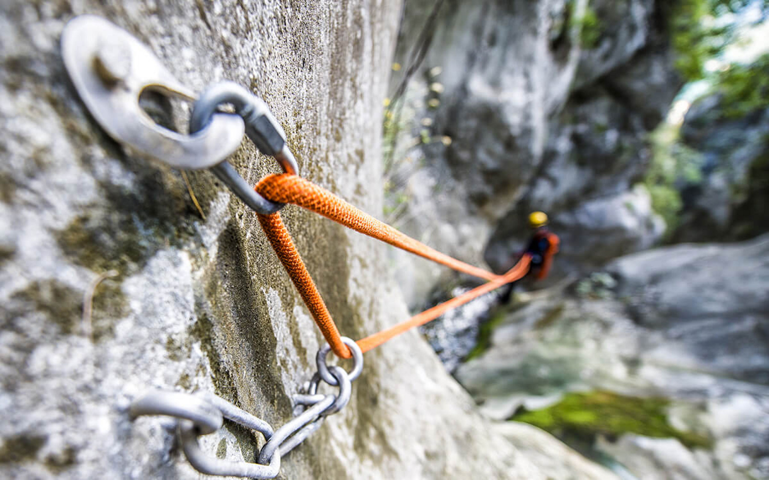 Eine Felswand mit Kletterhaken und einem Kletterseil