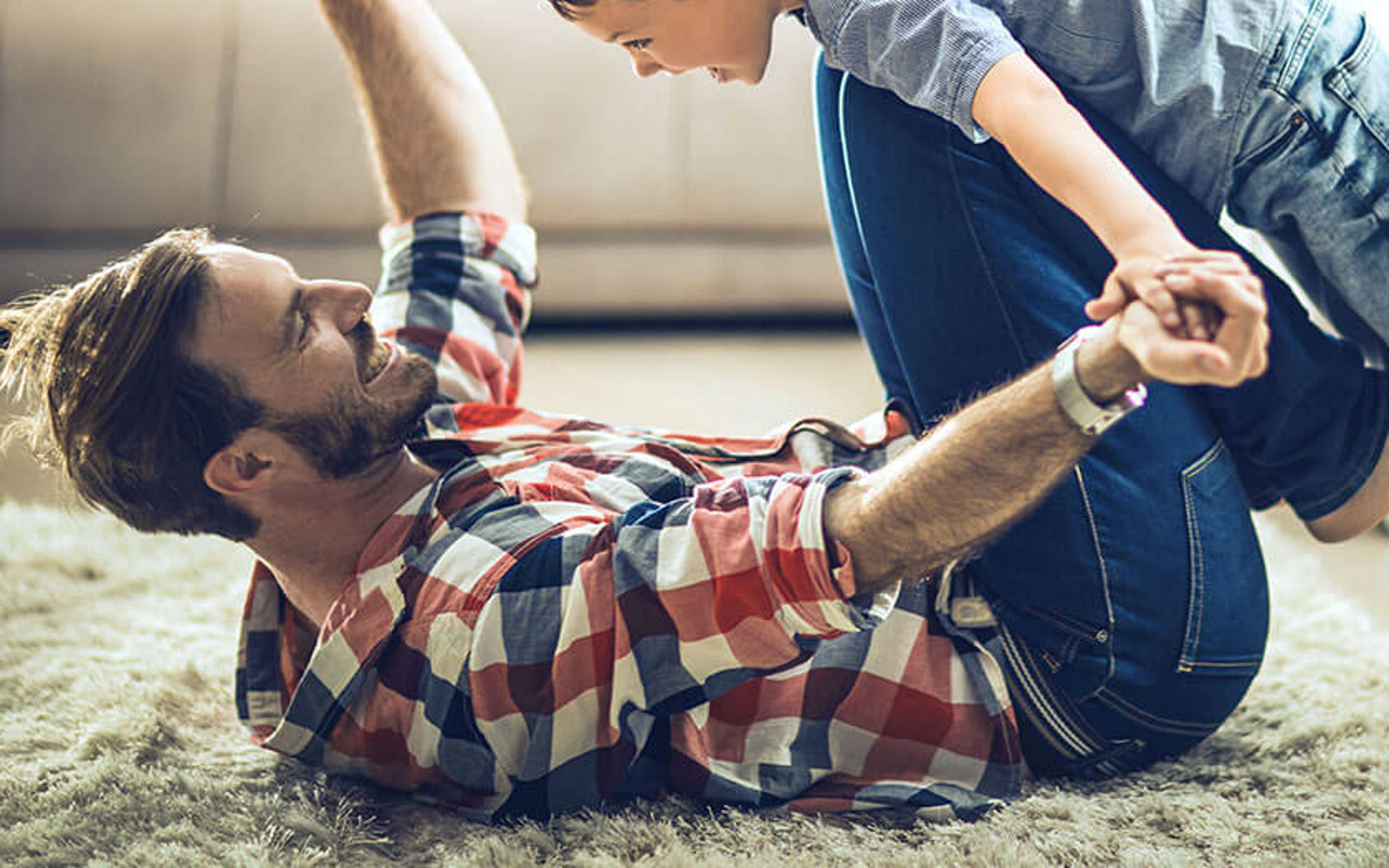 Vater und Sohn spielen auf dem Teppich