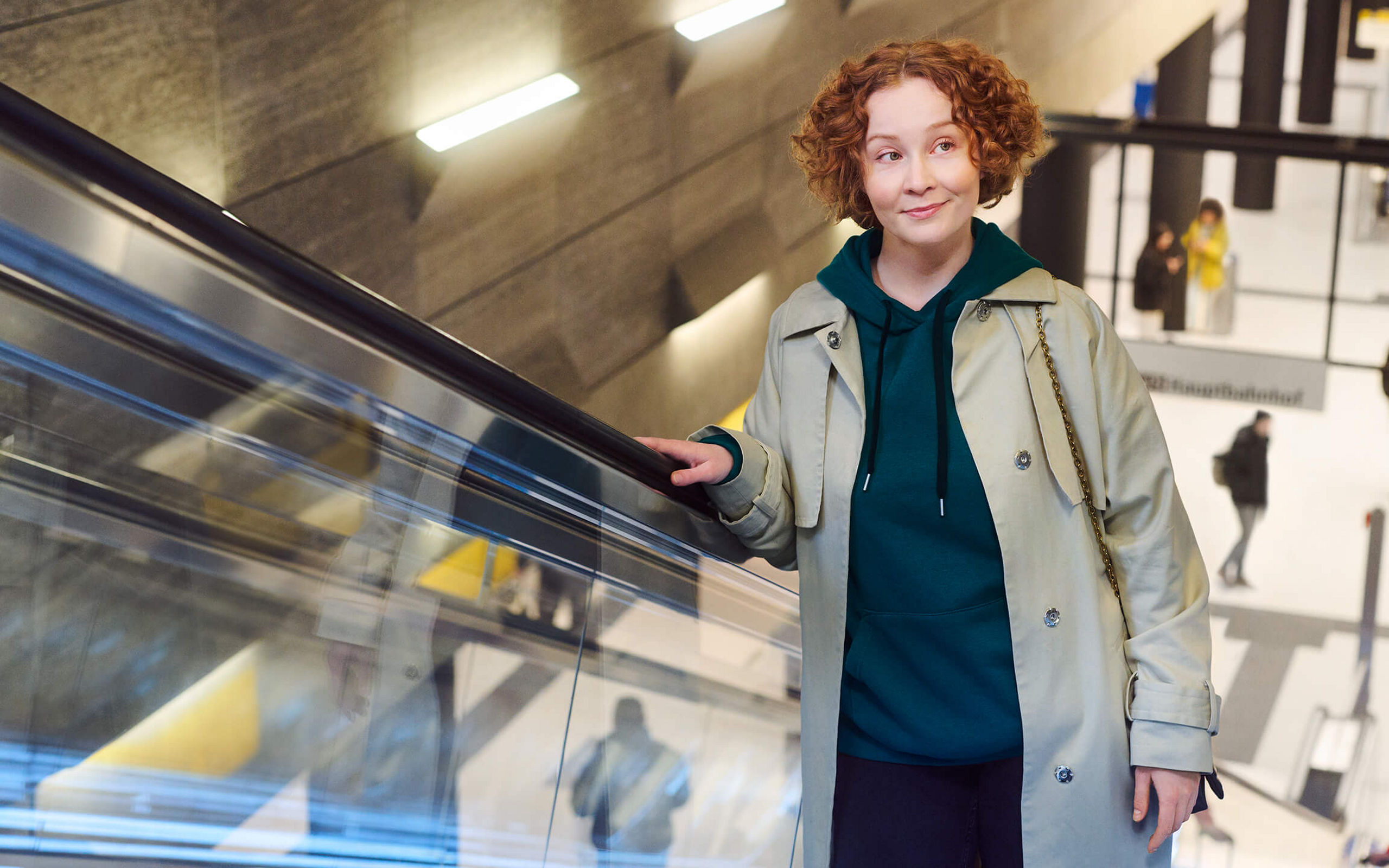 Eine Frau fährt auf einer Rolltreppe aus einer Haltestelle