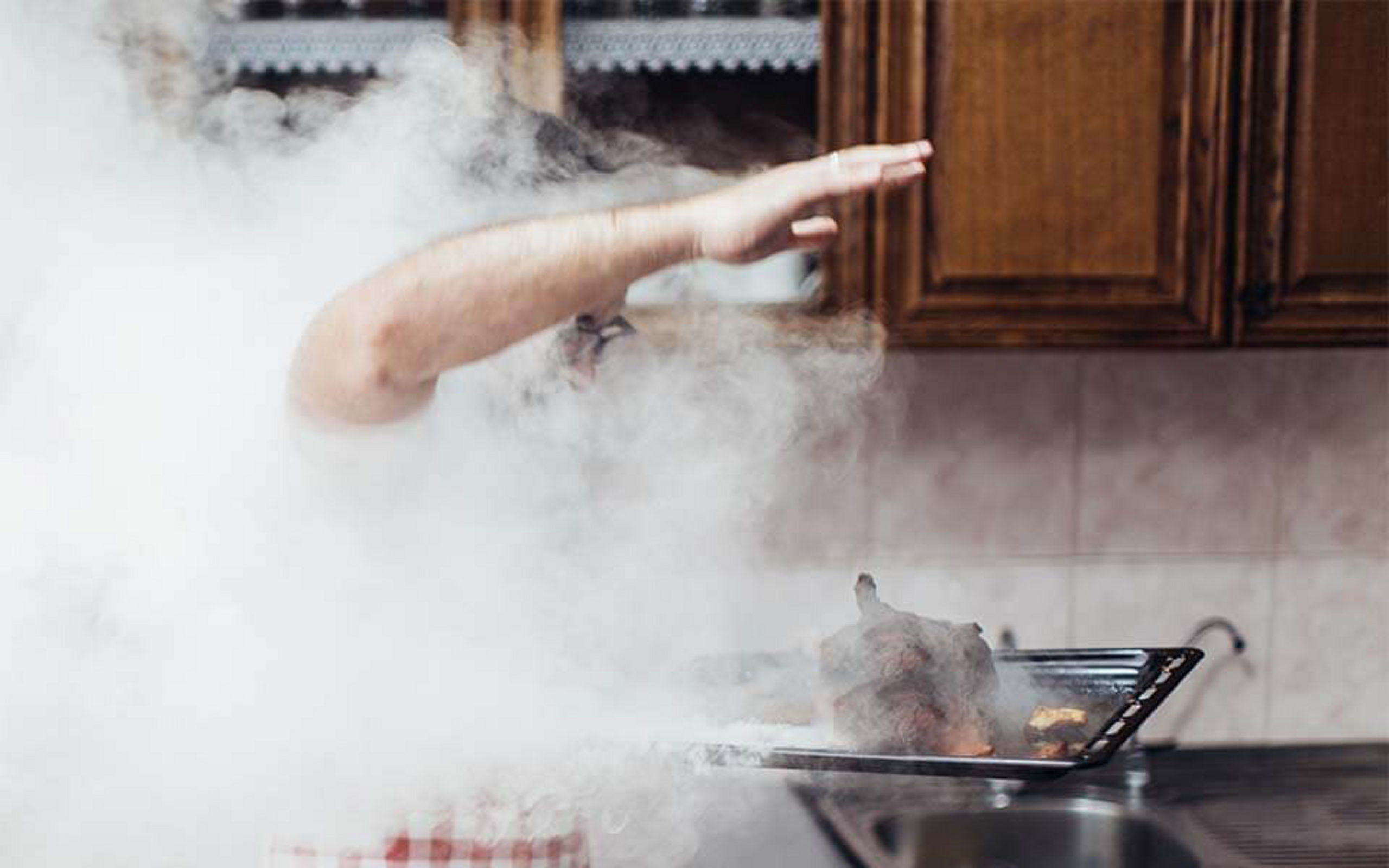 Ein Mann steht in der Küche mit einem verbrannten Essen