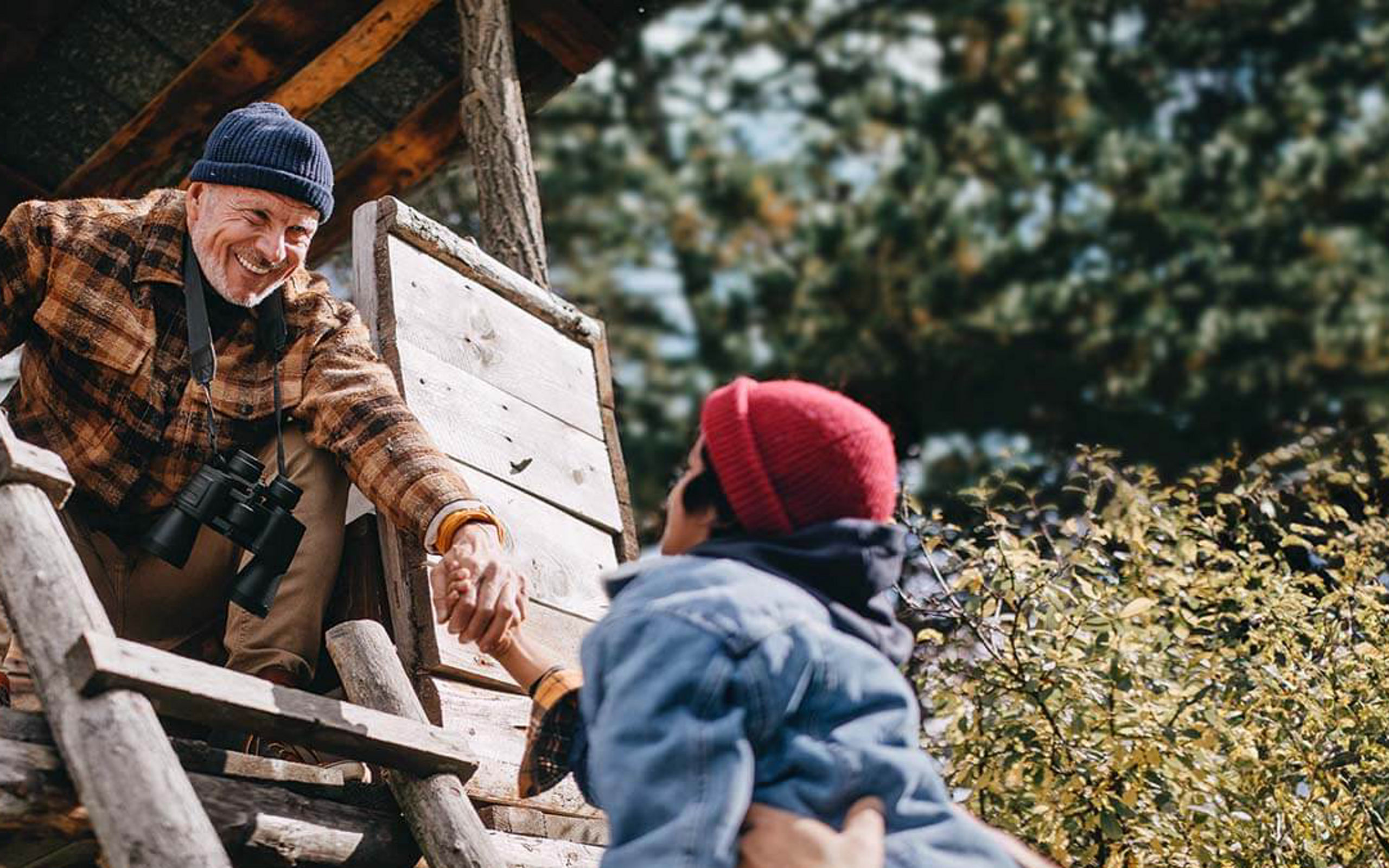 Ein Opa mit seiner Enkelin besteigen ein Baumhaus