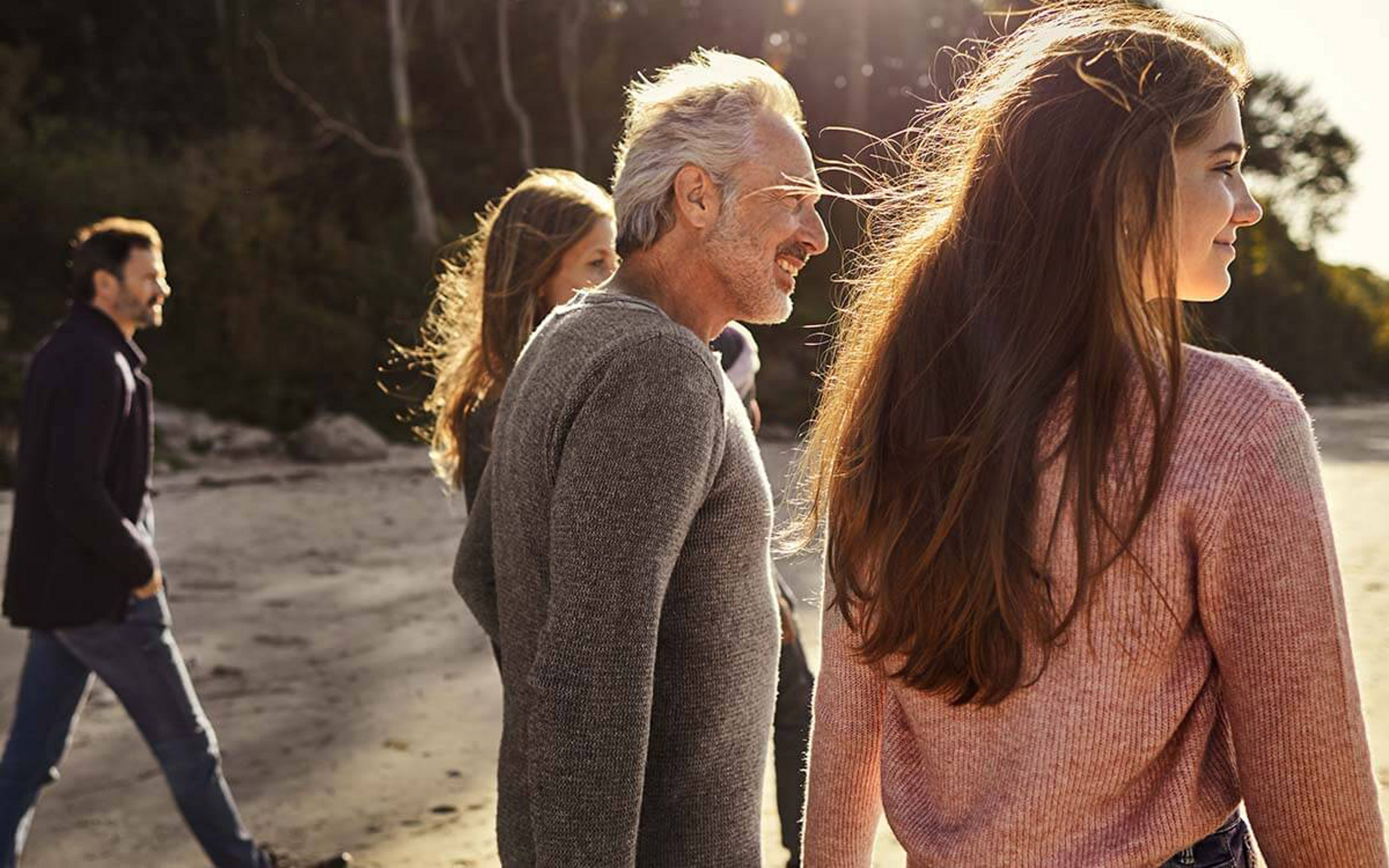 Eine Familie am Strand schaut in die Sonne