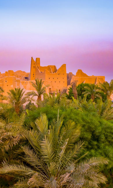 Diriyah at golden hour with historic architecture illuminated by warm evening light