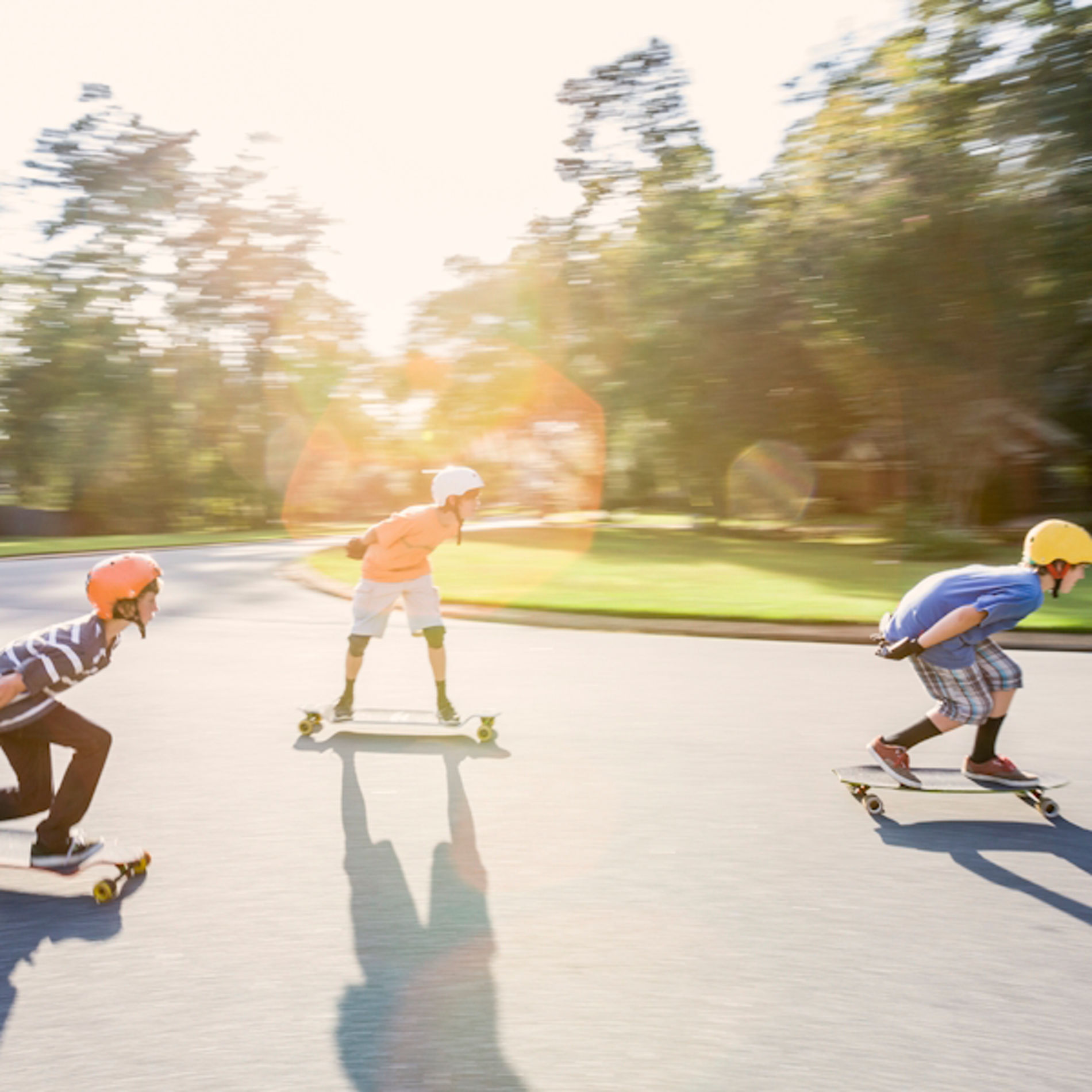 Drei Kinder fahren auf Skateboards