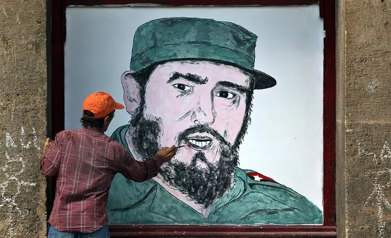Un hombre pinta un mural de Castro en La Habana, el domingo. Foto: EFE