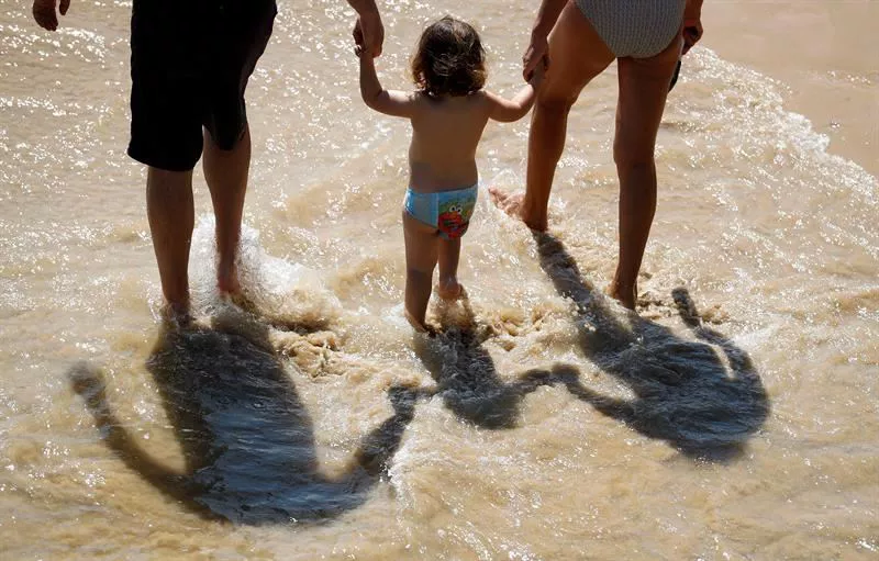 Familia bat, Donostiako Ondarreta hondartzatik paseoan.