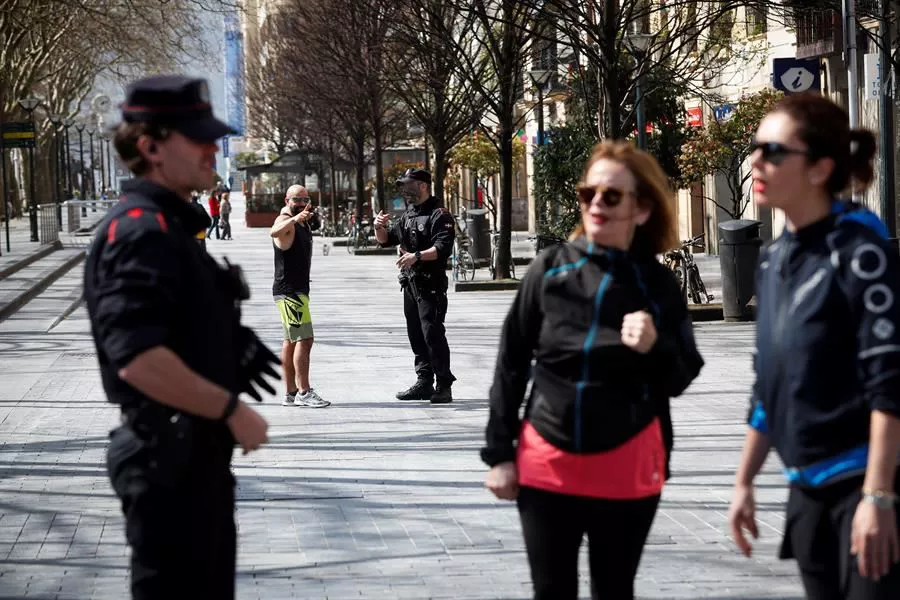 Dos ertzainas advierten a viandantes en Donostia. Foto: EFE