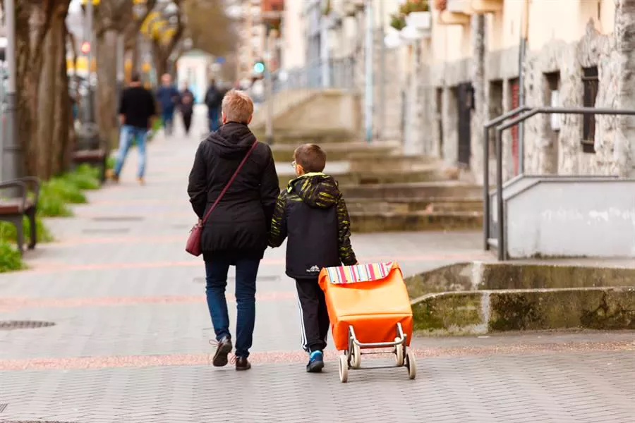 Un escolar acompaña a una mujer a la compra en Vitoria