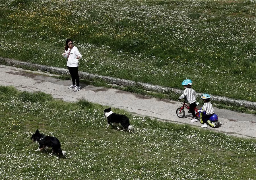 Emakume bat seme-alabekin eta txakurrekin paseoan, Iruñean. Artxiboko argazkia: EFE