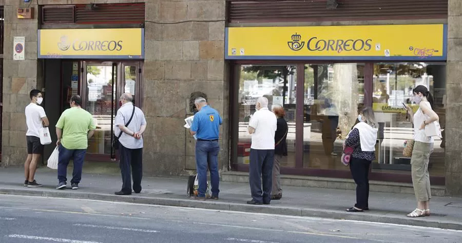 Gente haciendo fila en el exterior de una oficina de Correos en Bilbao