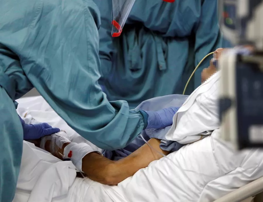 Personal sanitario atiende a un enfermo en una UCI.