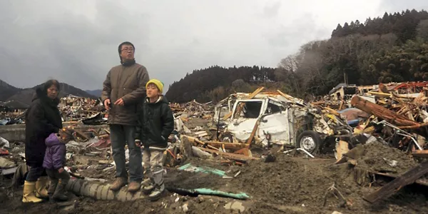 Familia rodeada de escombros causados por el terremoto. Foto: EFE