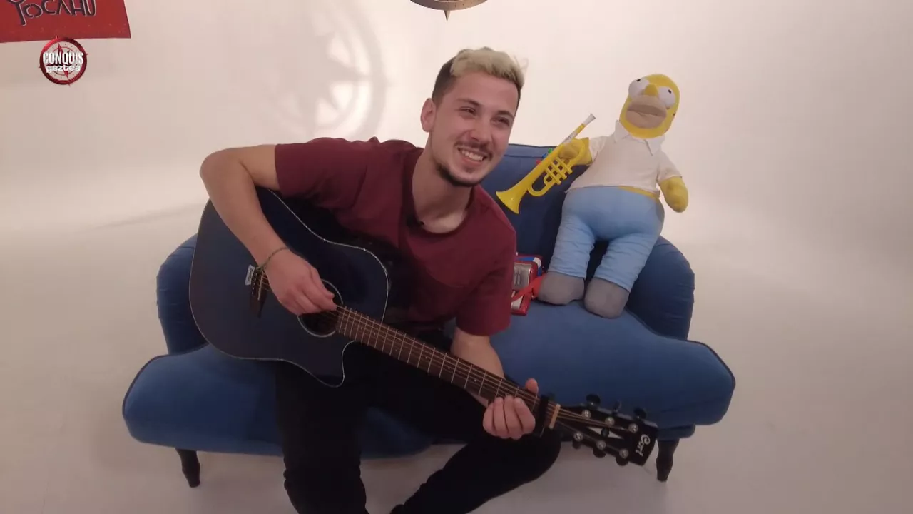 "Conquis"eko Dani gitarrarekin Ken Zazpiren kantak abesten. EITBren bideo batetik ateratako irudia