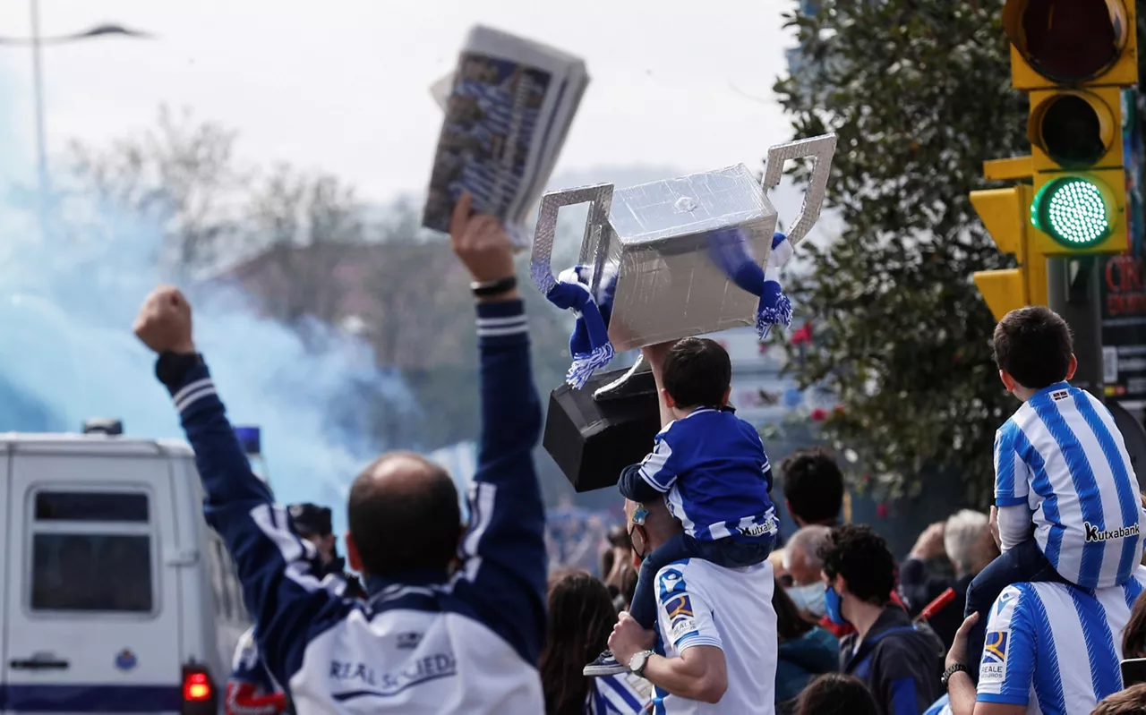 La afición de la Real saluda el paso del autobús. EFE