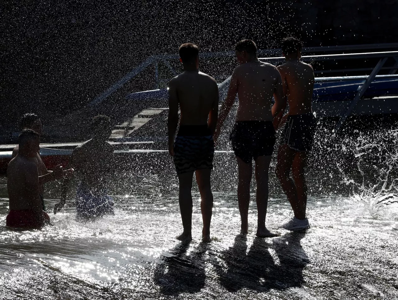 Unos jóvenes se refrescan en el Arga a su paso por Pamplona/Iruñea