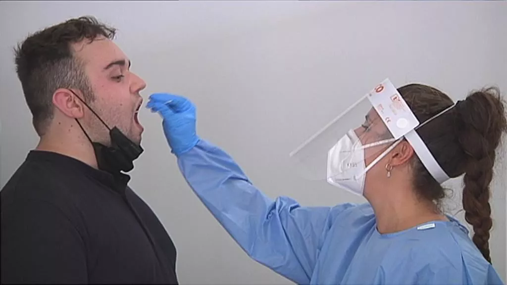 Personal sanitario realiza una prueba diagnóstica a un hombre.