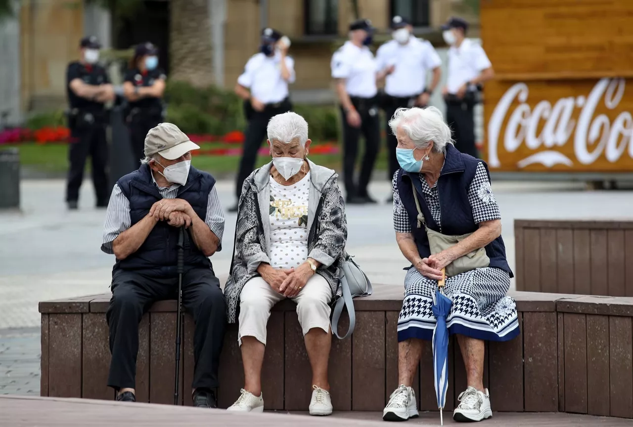 Un grupo de personas conversan en San Sebastián con la mascarilla puesta