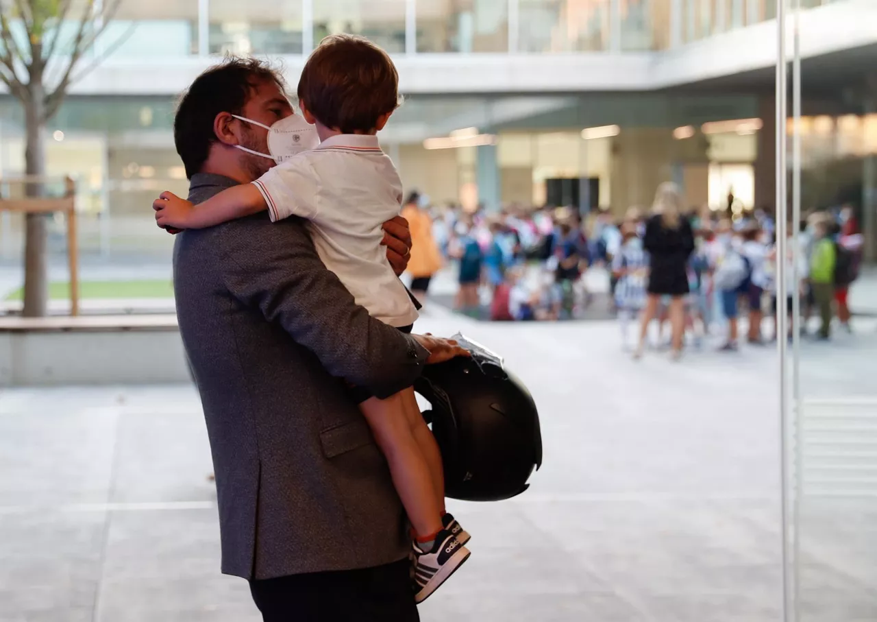 Un hombre con su hijo menor en brazos. Foto de archivo: