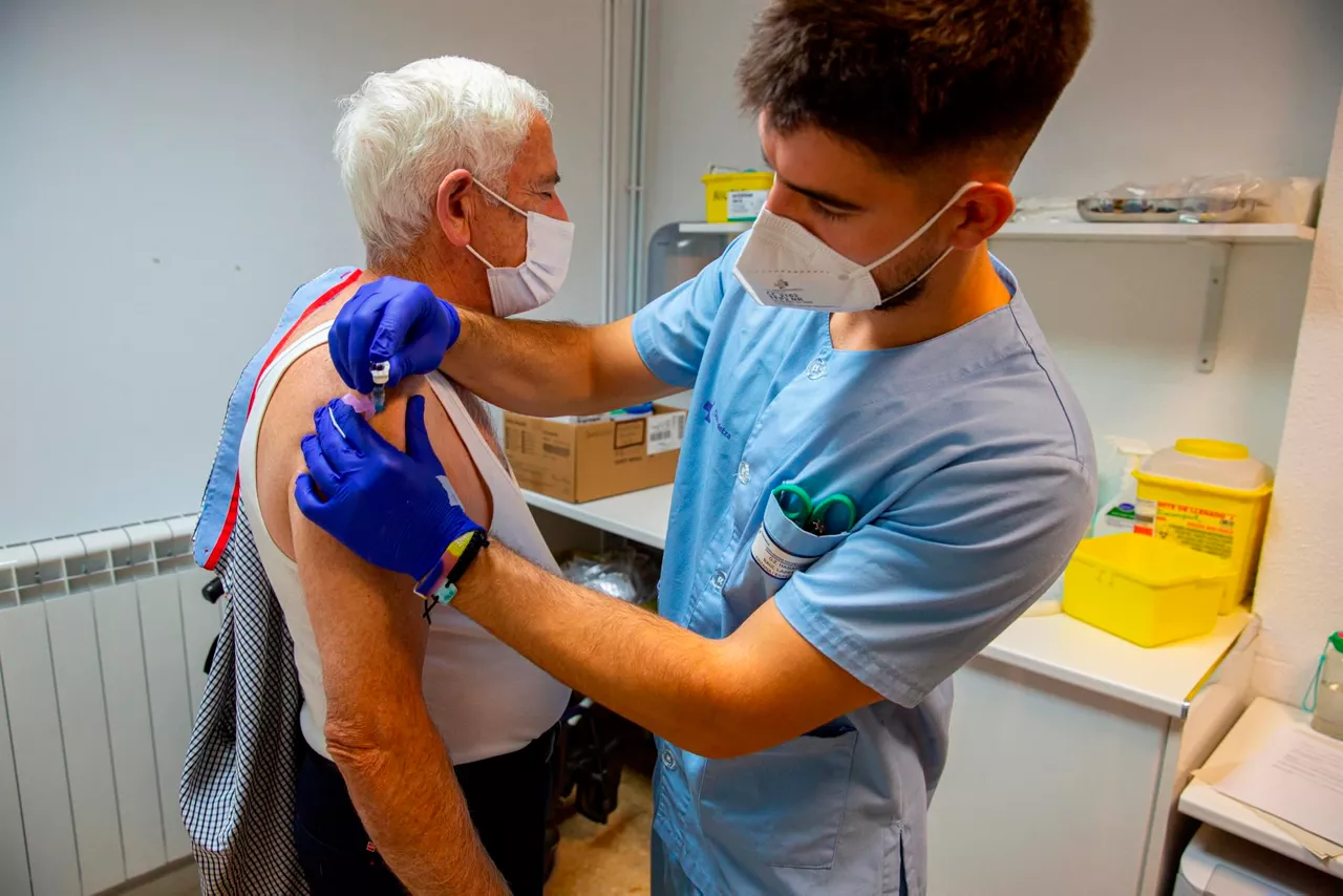 Una trabajadora sanitaria poniendo la vauna