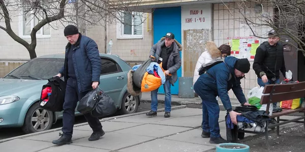 Víctimas del ataque a un edificio recuperan los enseres posibles. EFE