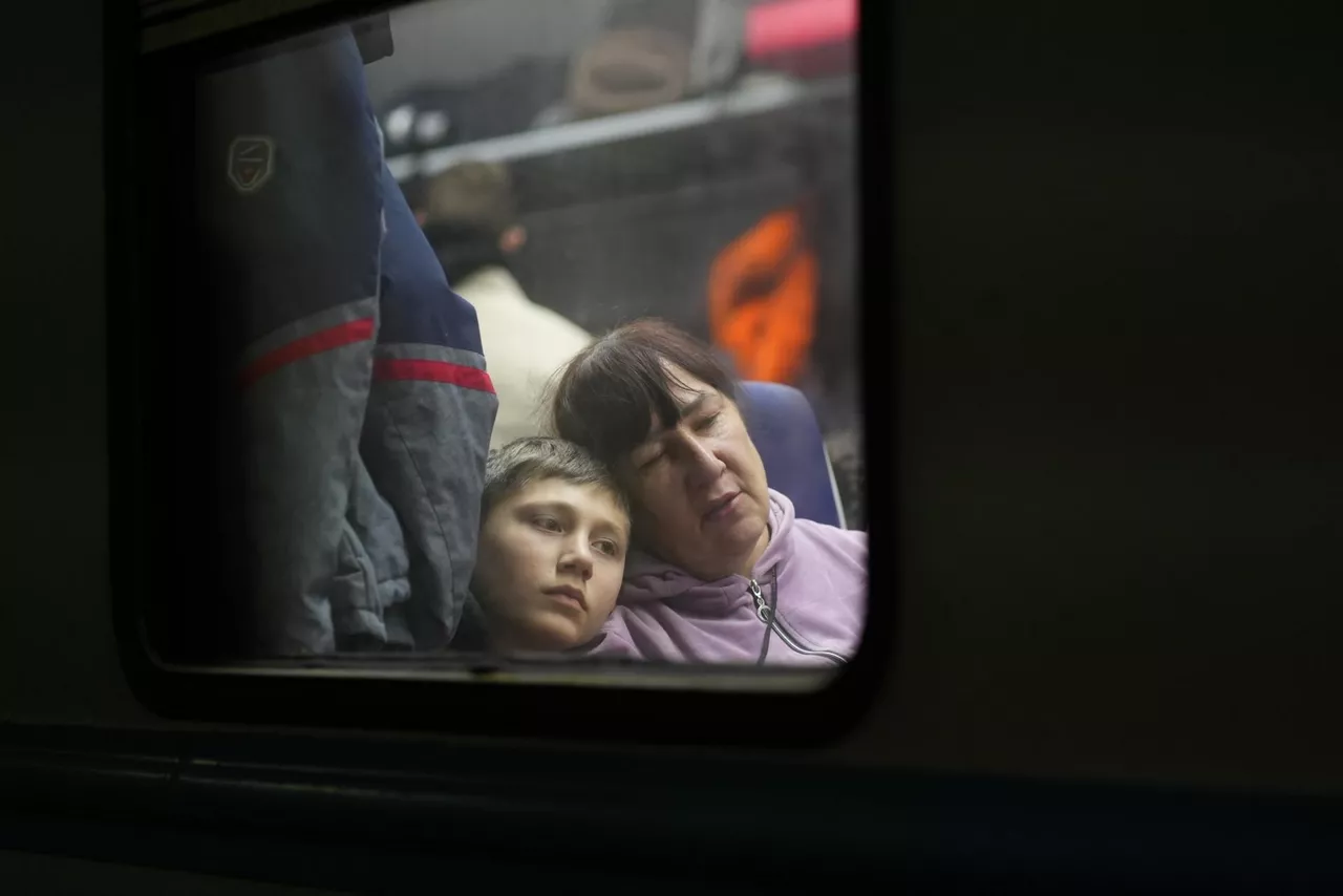 Mutiko bat eta emakume bat, Ukrainatik heldutako tren batean, Polonian.