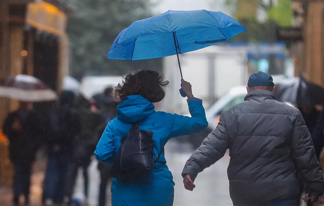 Dos personas corren bajo la lluvia.