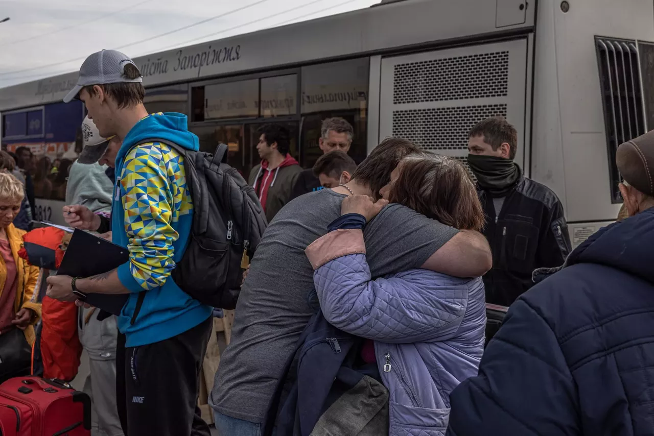 Personas evacuadas de Mariúpol se abrazan a su llegada a Zaporiyia. Foto: EFE