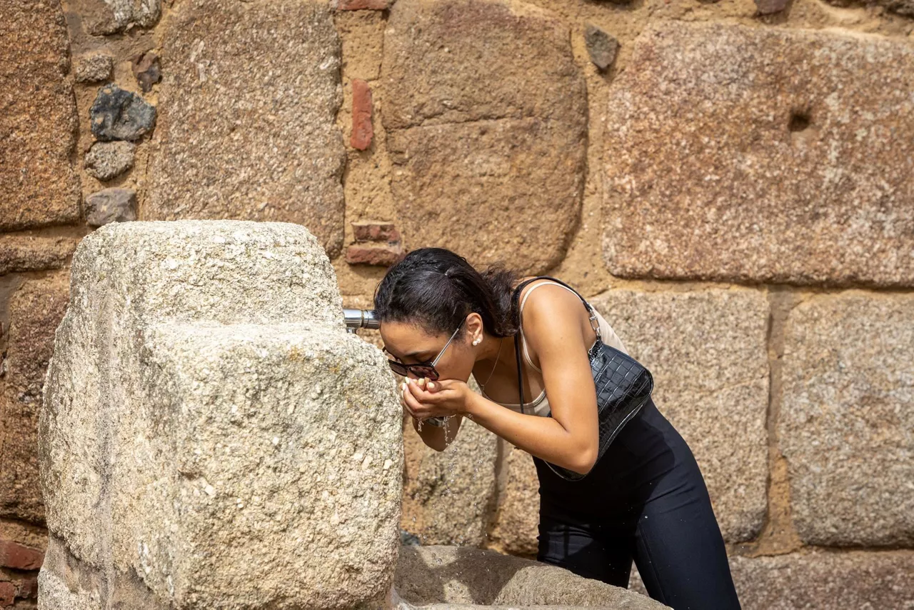 Una mujer se refresca en un día de calor sofocante.
