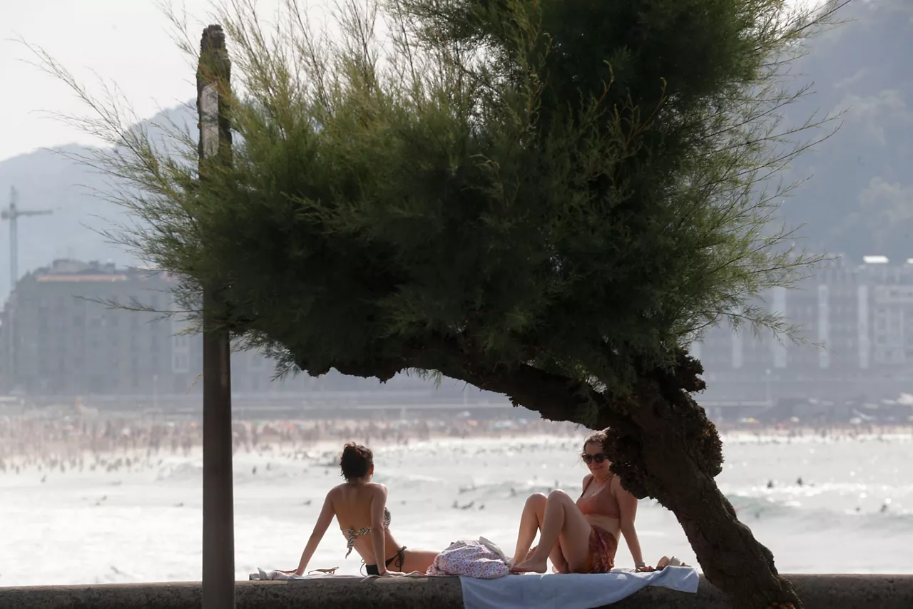 Gente a resguardo del calor en Donostia. EFE