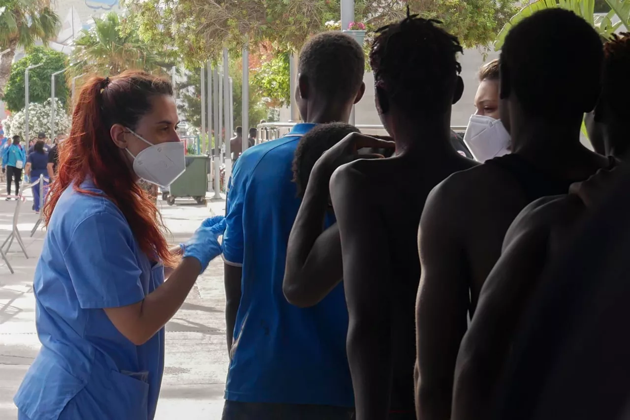 Personas migrantes en Melilla, siendo atendidas por personal sanitario. Foto: EFE