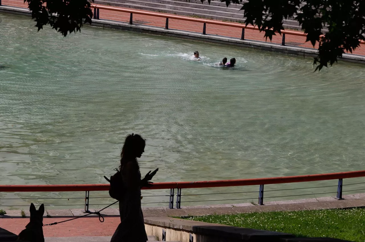 Varias personas se refrescan en Bilbao.