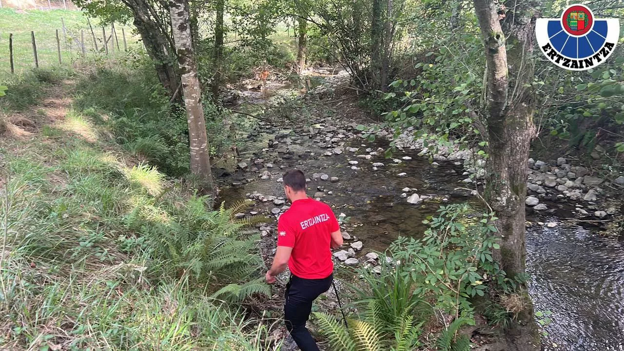 Un agente busca en las inmediaciones de un riachuelo de Dima.