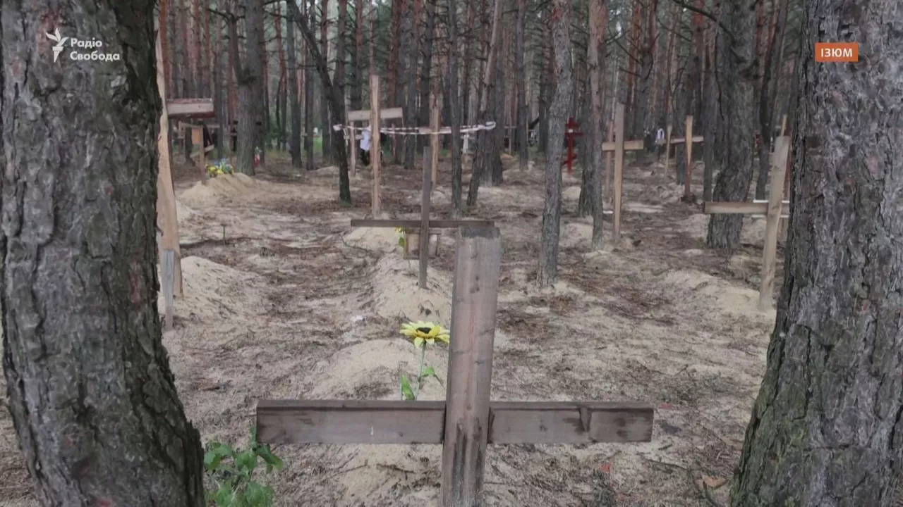 Tumbas sin identificar en Izium. Imagen obtenida de un vídeo de Reuters.