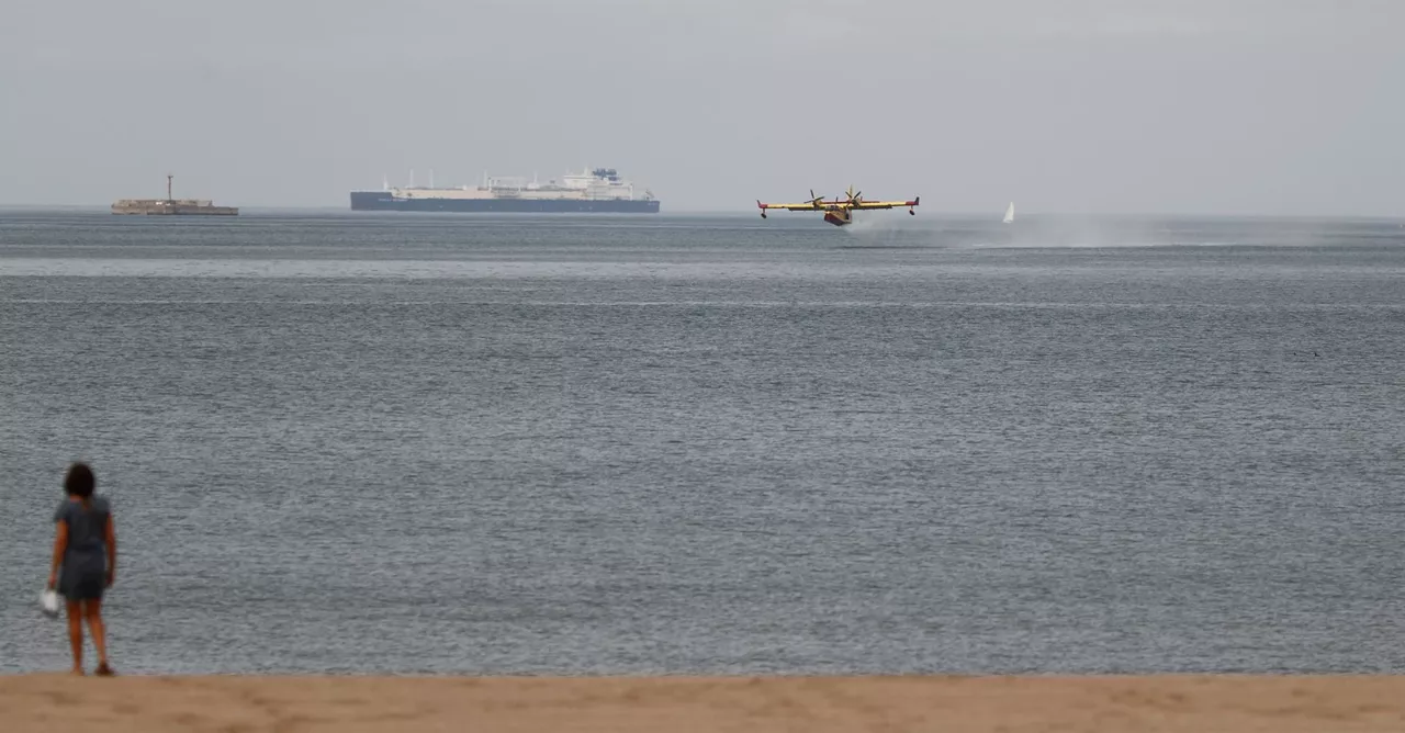 Un avión anfibio cargando agua en la playa de Ereaga. Foto: EFE