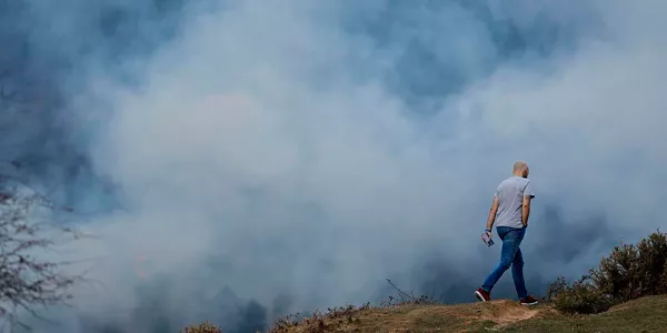 Pertsona bat Zugaztietako sutearen aurrean. Argazkia: EFE