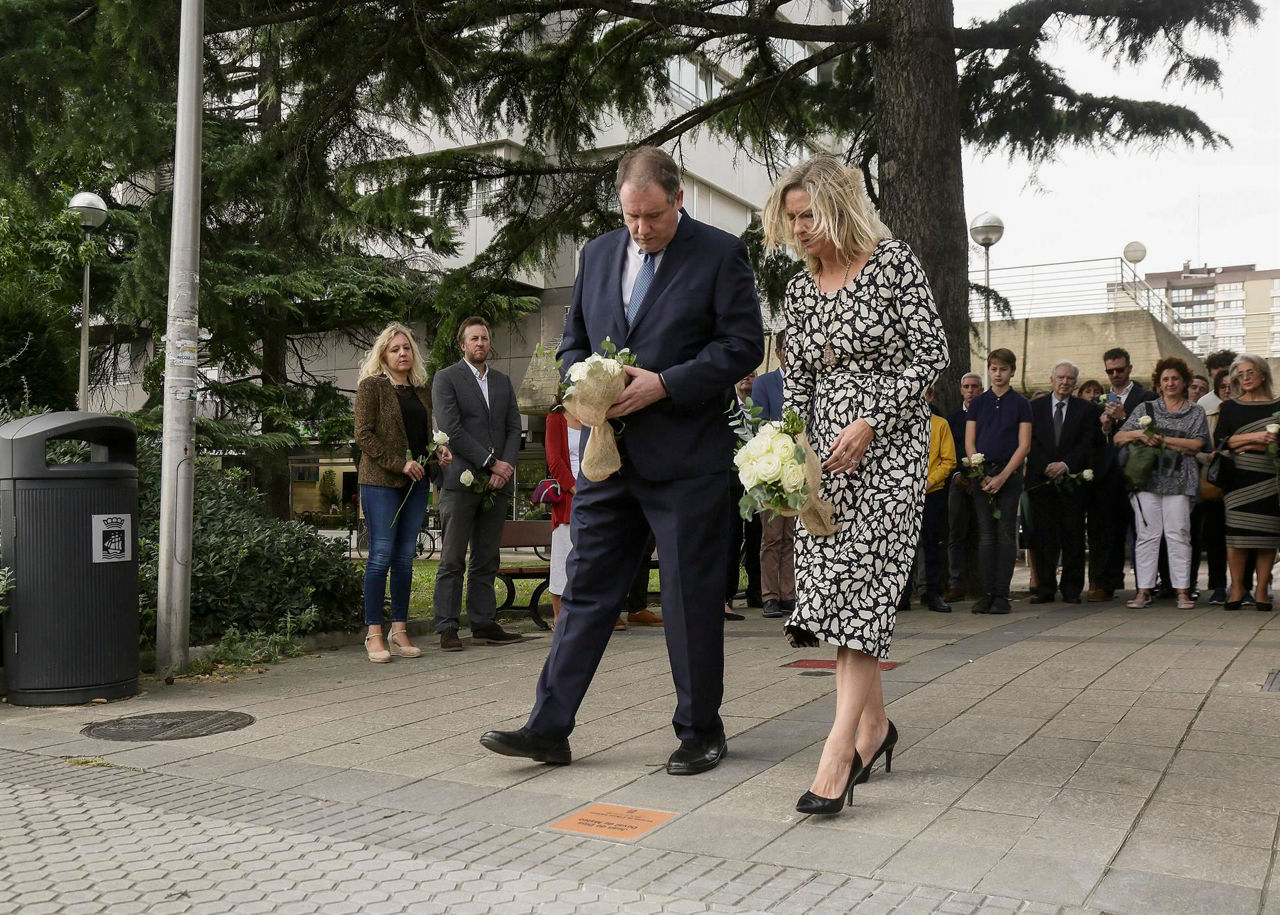 Dovalen seme alabak, aitari loreak eskaintzen. EFE.